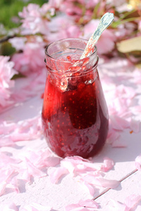 一罐新鲜覆盆子果酱质朴表满了樱，浪漫早餐背景灯关闭，在花园里