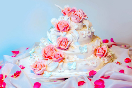 白多层婚礼蛋糕，粉红玫瑰花朵装饰