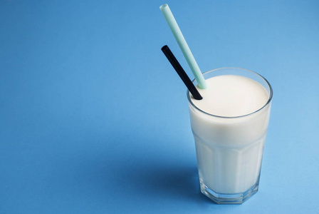 玻璃牛奶秸秆孤立的蓝色背景乳糖乳制品
