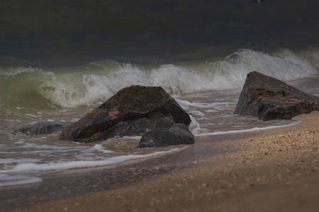 强大的海浪破碎岩石的海滩上
