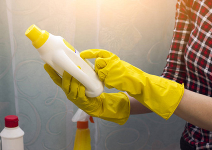 一个穿黄色手套的女孩读了一本关于清洁, 特写的指令。