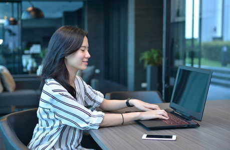 休闲商务亚洲女人微笑和在公寓中使用一台笔记本电脑