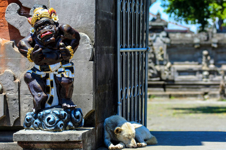 乌布古庙的五彩雕塑。印度尼西亚的地道建筑。一只睡在庙门口的狗