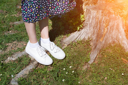 绿色草坪上白色运动鞋的女性脚