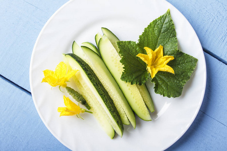 新鲜切片的黄瓜, 绿叶和黄色的花, 用于膳食早餐或午餐。天然有机蔬菜。顶部视图