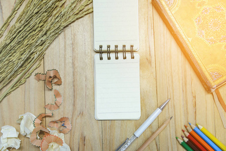 小注书纸 记事本 编写信息用笔，彩色铅笔，铅笔，书和皱巴巴的纸球木制的桌子上。从上面查看
