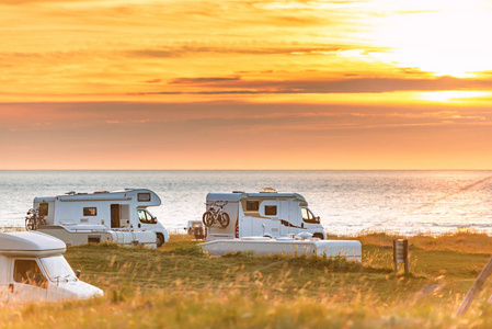 在挪威, 欧洲的日落休闲车。草地和海岸多云的天空和太阳。旅行由 Rv. 北欧国家, 欧洲, 斯堪的纳维亚