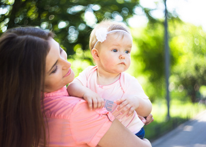 Youmg 幸福的女人和她可爱的小宝宝夏天阳光公园户外玩。Mothercare 图片