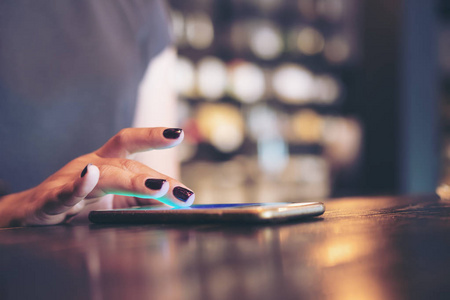一个女商人手触摸和滑动手指在现代咖啡厅在智能手机上