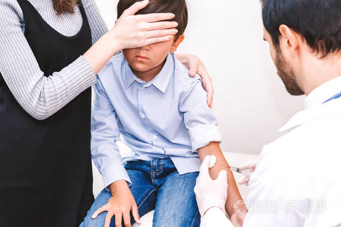 医生在医院的医生桌上给孩子和妈妈注射防护手套医疗保健