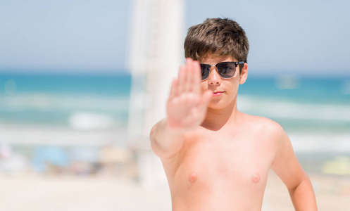 小孩子在假日由海滩用张开的手做停止标志以严肃和自信的表示, 防御手势