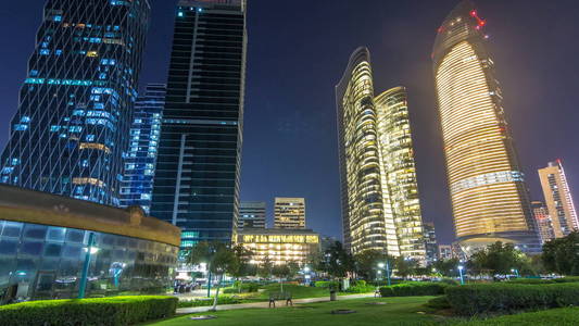 阿布扎比的摩天大楼在夜间 timelapse hyperlapse, 阿拉伯联合酋长国。从海滨景观与照明现代塔