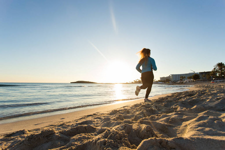 运行在日出海滩的年轻健康的生活方式健身女人