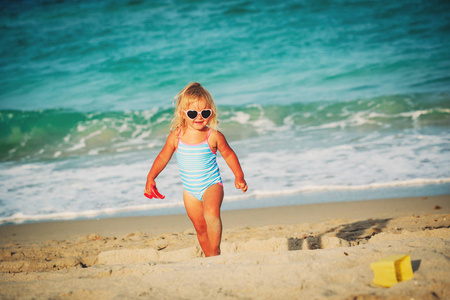 可爱的小女孩在海滩上玩沙子