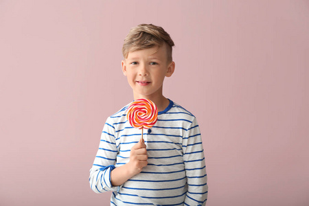 可爱的小男孩与棒糖在颜色背景