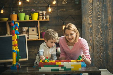 享受概念。母亲和孩子喜欢玩玩具砖。母亲和儿子学习享受和享受学习
