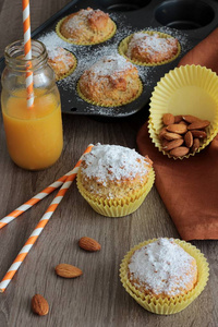 新鲜的自制橙色松饼木桌背景上。用螺母面粉的迷你蛋糕。健康烘焙食品