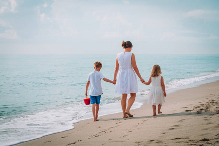 母亲与 kdis儿子和女儿漫步在海滩上
