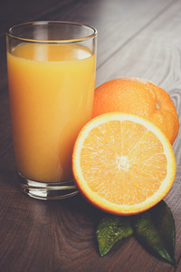 新鲜橘子和玻璃桌上汁