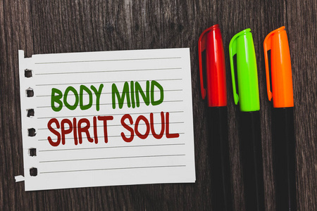 手写文字正文心灵精神灵魂。概念意指个人平衡疗法意识状态的心彩字与白页红绿橙笔在黑木桌上