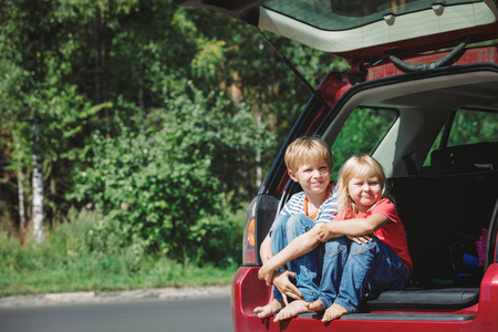 快乐的小女孩和男孩乘汽车旅行