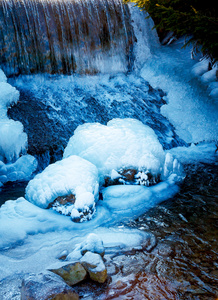 冬天的场面与水从冰雪覆盖的岩石落下