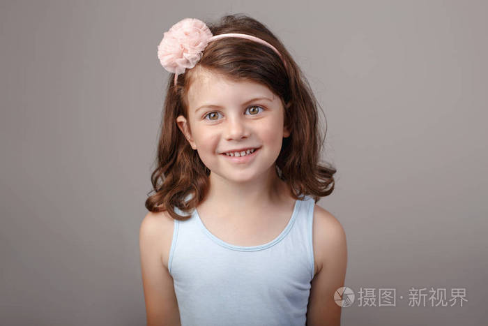 特写肖像的可爱可爱的白色黑发白人少女在镜头前做鬼脸.