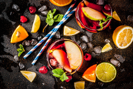 夏季冷鸡尾酒, 水果和浆果红酒桑格里亚苹果, 柠檬, 桔子和覆盆子。深色背景, 复制空间顶部视图