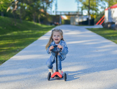 3岁的小女孩骑着滑板车