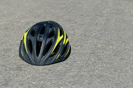 在沥青上的自行车头盔。道路安全