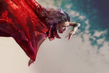 梦幻般的仙女飞。穿着红色连衣裙的飞行妇女的神话般的肖像