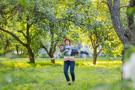 春天公园开花苹果树附近的母亲和女儿的肖像