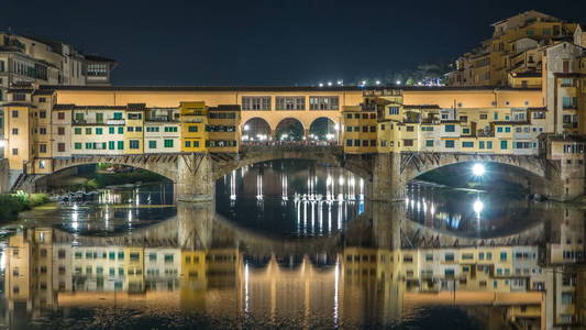 著名的蓬 桥时差在意大利佛罗伦萨的阿诺河上, 在夜间点燃。水的倒影。老房子在边