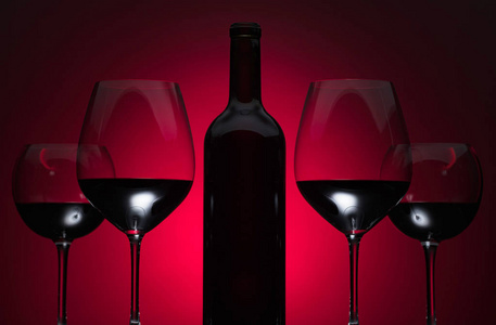 红色背景的红酒杯和酒瓶