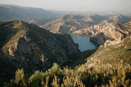 西班牙日落时, 位于古山谷底部的一个小翡翠湖, 覆盖着绿色森林。