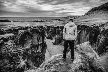 游客反对风景如画的冰岛景观。黑白照片