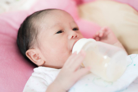 亚洲 1 月男孩婴幼儿吃牛奶从瓶子里