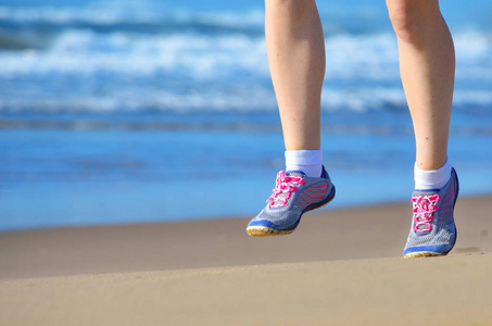 健身和运行在沙滩上，在接近海 健康的生活方式和体育概念的沙滩上锻炼的女跑步运动员