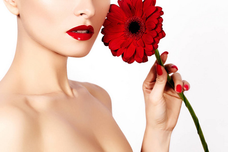 特写美写真女人与红红的嘴唇 口红和美丽的红色花。水疗中心清洁皮肤