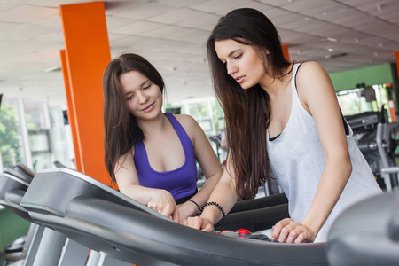 试图把健身房印在跑步机上的两个漂亮女人
