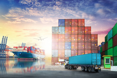 物流进口出口背景和运输行业的集装箱卡车和货船在海港在落日的天空