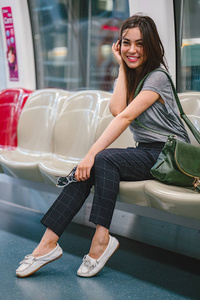 一位年轻漂亮的日本亚洲旅游妇女, 坐在亚洲的火车上度假。她很可爱, 很有魅力, 当她在座位上放松时, 她笑得很开心。
