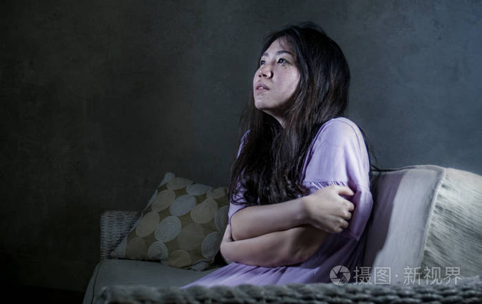 年轻的忧郁和沮丧的亚洲日本妇女在家里沙发沙发哭绝望和无助的痛苦