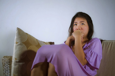 年轻的忧郁和沮丧的亚洲韩国妇女在家里沙发沙发哭绝望和无助的痛苦焦虑和抑郁感觉痛苦在关系和孤独的生活问题概念