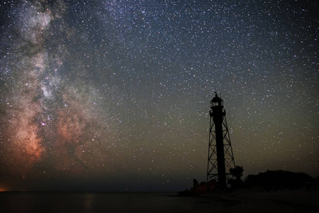 旧灯塔的剪影沙滩和海洋对星空的背景