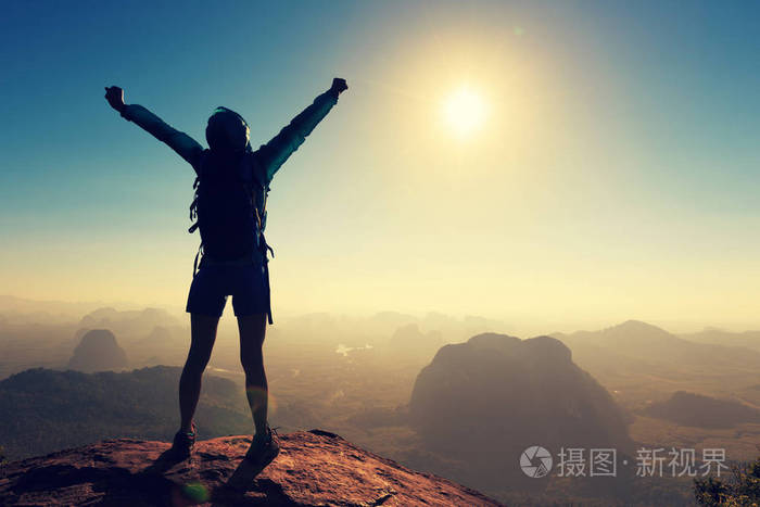 成功的女人站在山顶上