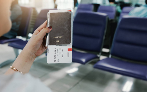 妇女手持有护照和机票在机场