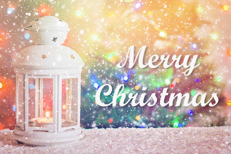 圣诞快乐。圣诞白色灯笼与燃烧的蜡烛在圣诞树的背景, 花环的灯, 散景