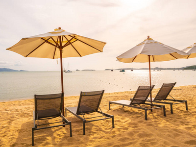 在日出时的热带海滩海洋和海洋的雨伞和椅子旅行和度假