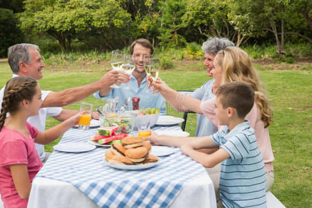 一代又一代的家庭在外面的晚餐上互相敬酒